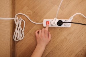 aerial view of female hand turning off power strip