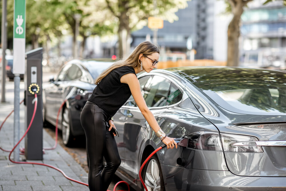 Woman charging an EV on the street