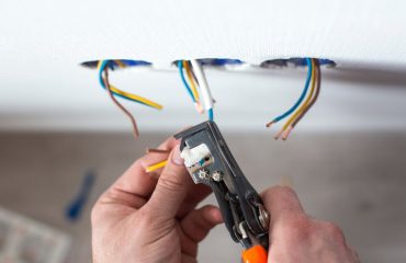 Electrician is upgrading aluminum to copper wiring in a home. This photo shows removing insulation from wires