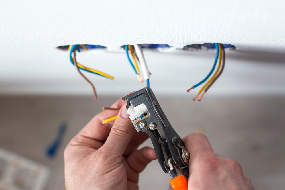 Electrician is upgrading aluminum to copper wiring in a home. This photo shows removing insulation from wires