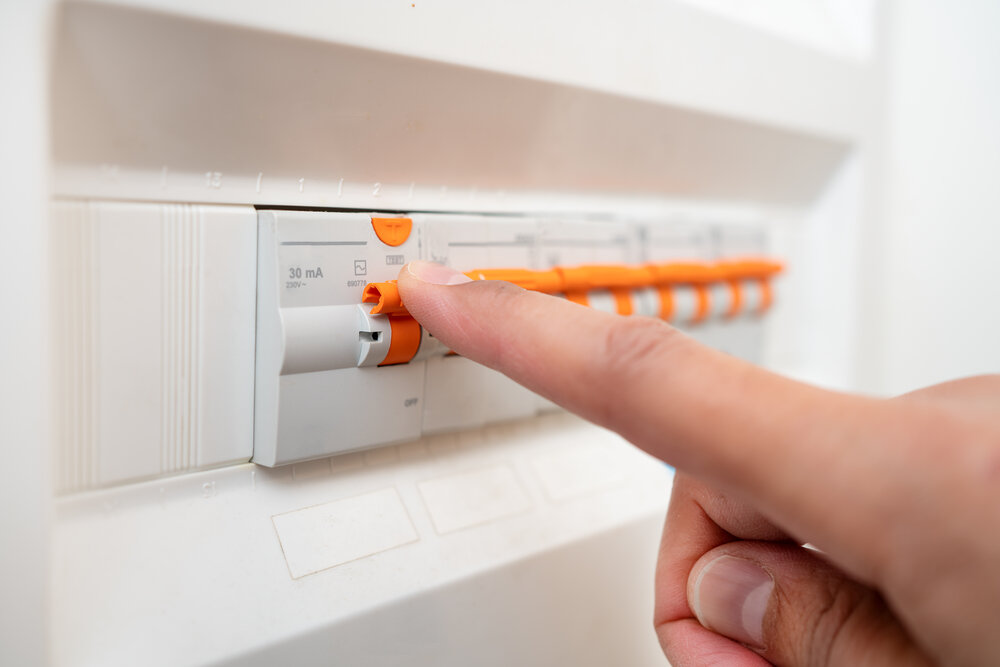 Close up of man hand and electrician with electricity fuse box, check power supply with maintenance on main circuit breaker switch. Engineer, technician and male worker with handyman