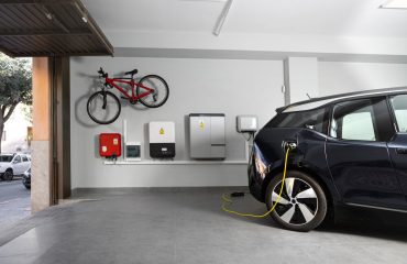 Electric black vehicle using electric car charging station at home. EV Charging Station at home